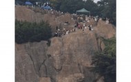 大连一跨海大桥观景台有游客翻栏杆踩空心造景石拍照，当地回应